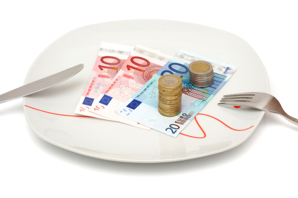 Bien manger pour pas cher: réaliste ou non? Une assiette pleine de billets et de pièces d'euros